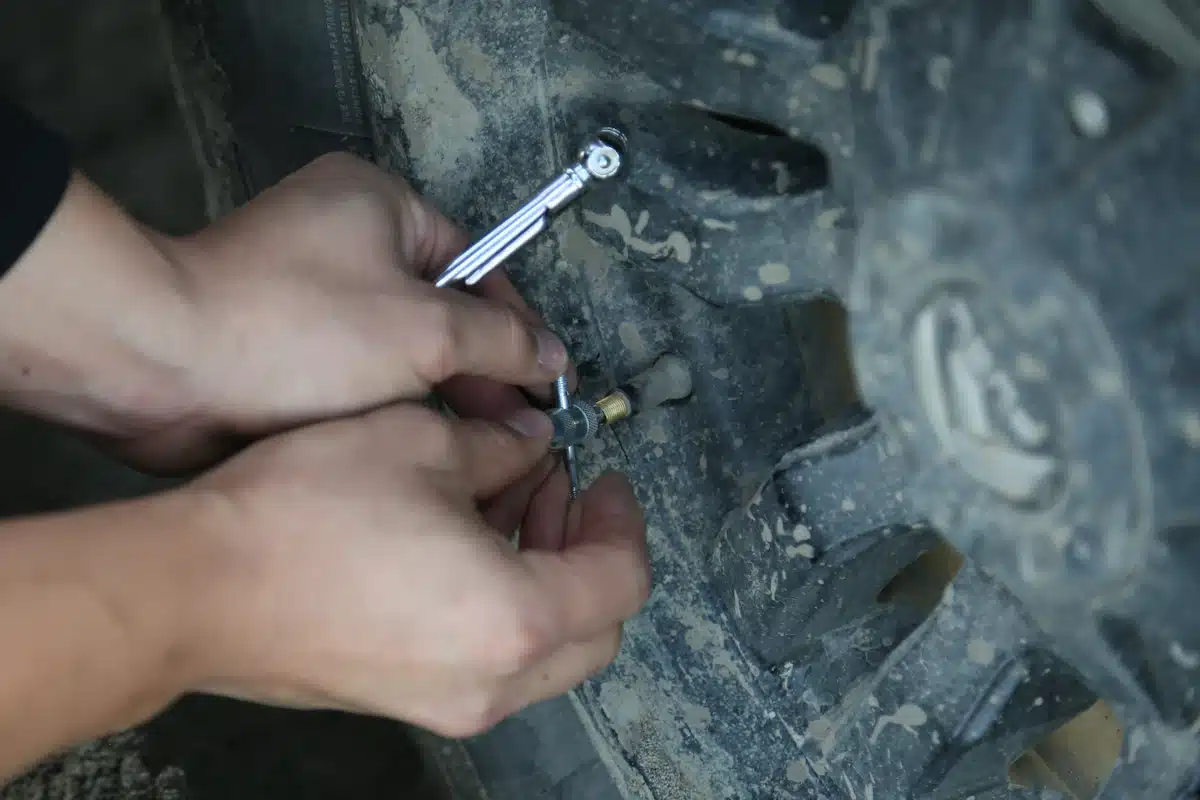 Person checking air pressure at a vehicle tire