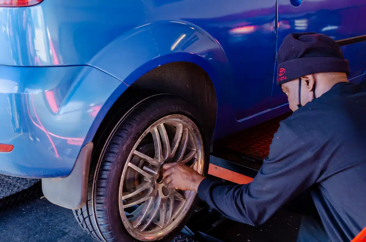 Driver inspecting a tire beside a vehicle