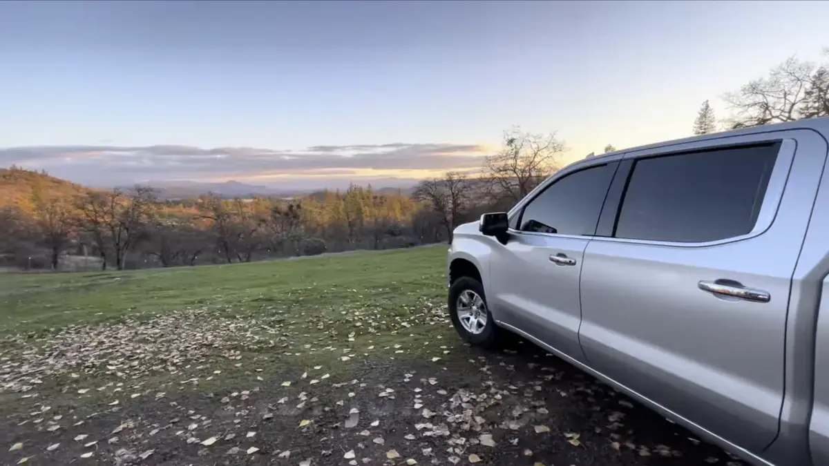 Silver 2020 Chevrolet Silverado 1500 parked beside a wooded hillside