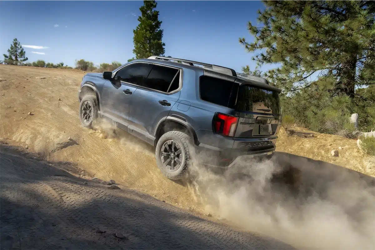 2027 Honda Passport TrailSport climbing a steep dirt grade, rear three-quarter view