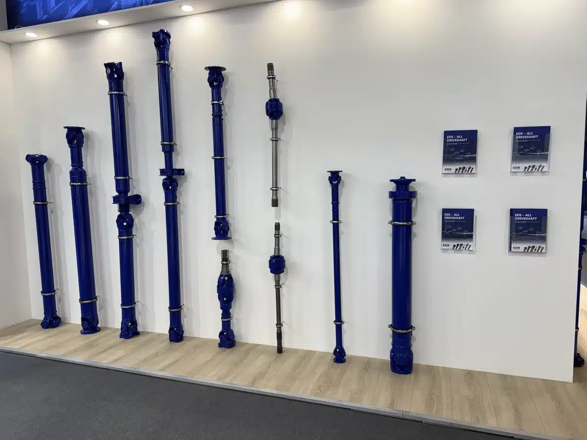 Driveshafts of different sizes line a display wall.