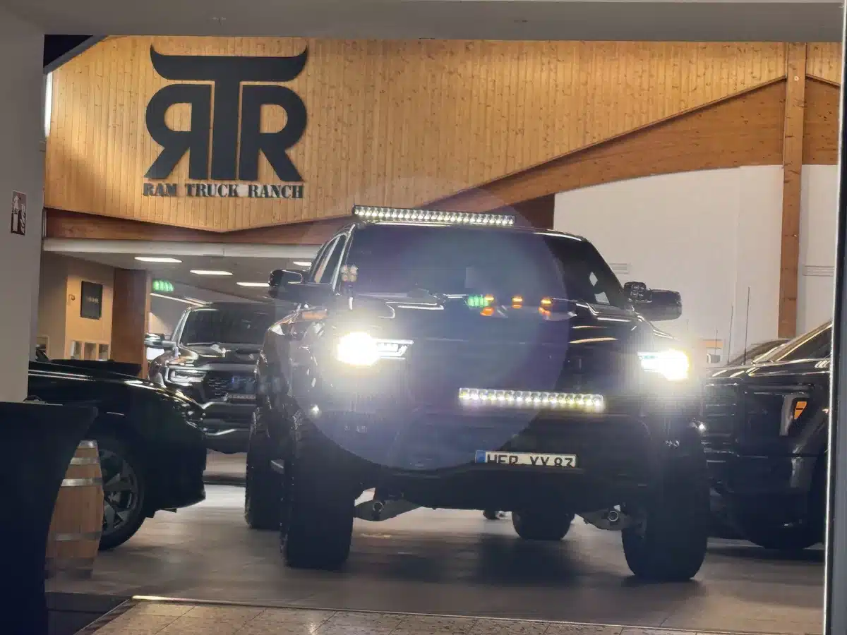 Customized Ram pickup with bright front lights illuminated.