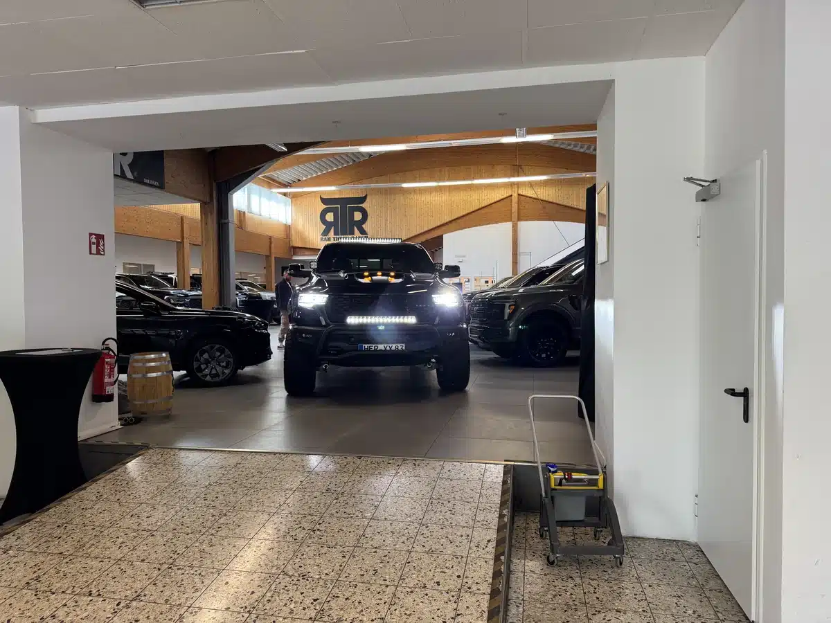 Wide view of the showroom entrance with a Ram pickup inside.