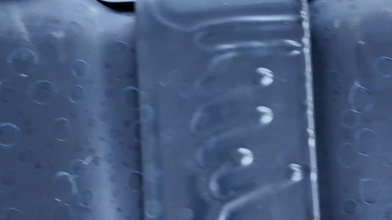The camera shows the light-duty truck’s coated frame and nearby underbody hardware.