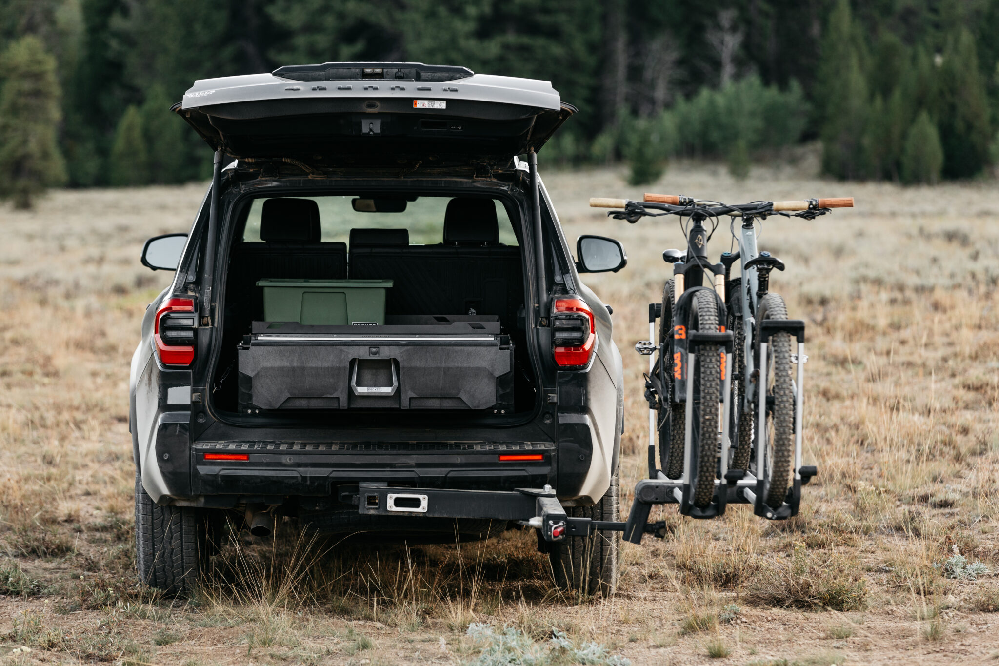 DECKED storage installed in a Toyota 4Runner with mountain bikes beside the rear cargo opening.