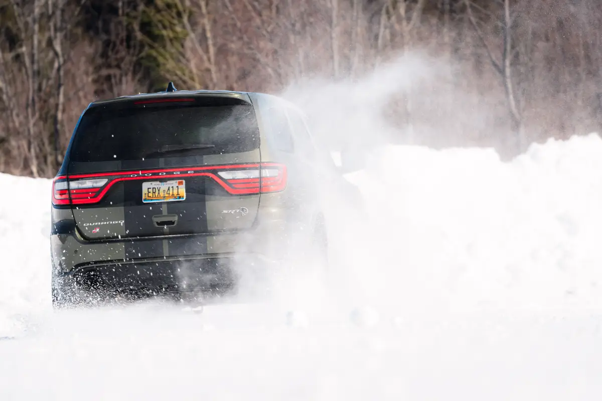 Dodge Durango driving through snow with its rear taillights visible