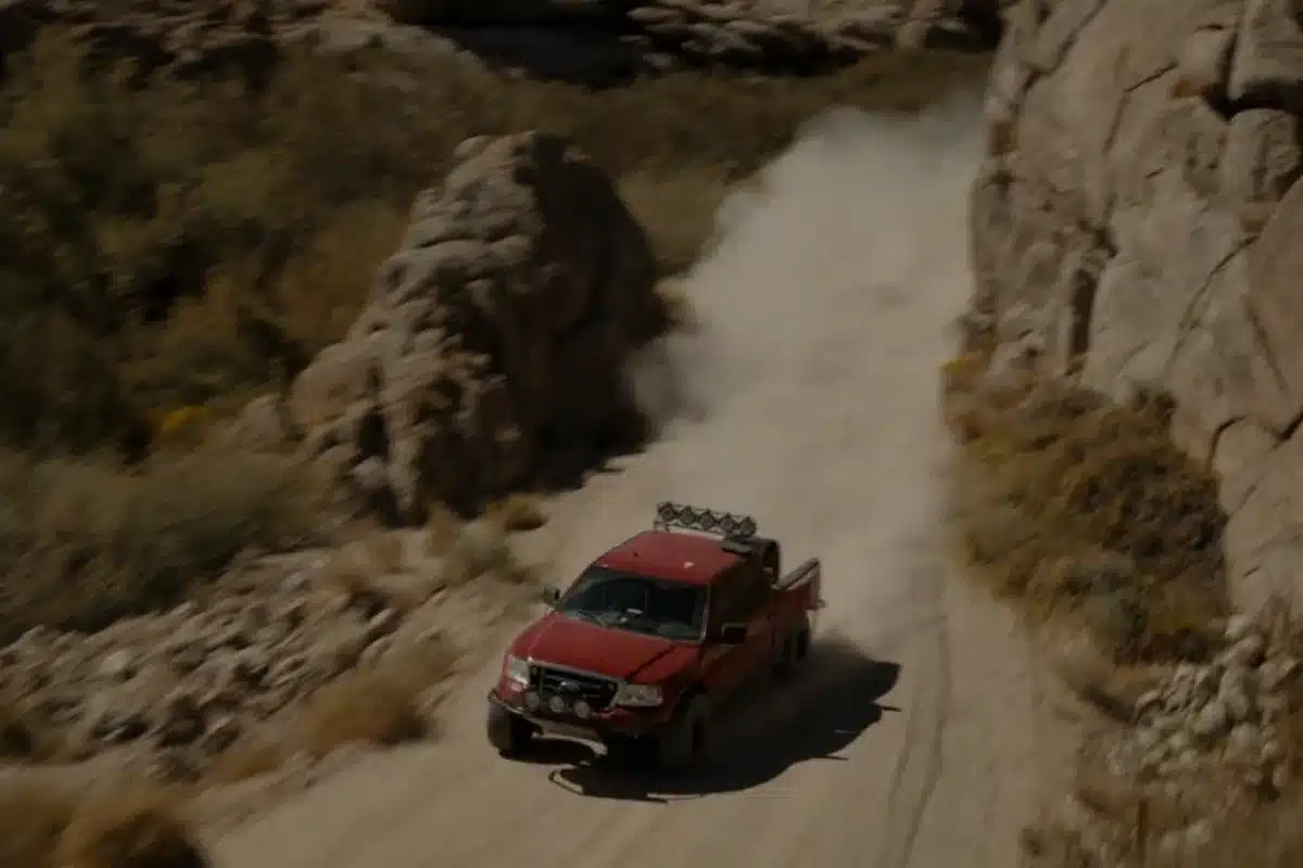 A red Ford Raptor on a desert course